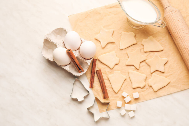 Pergamino con galletas e ingredientes sin cocer sobre fondo blanco - Foto, imagen