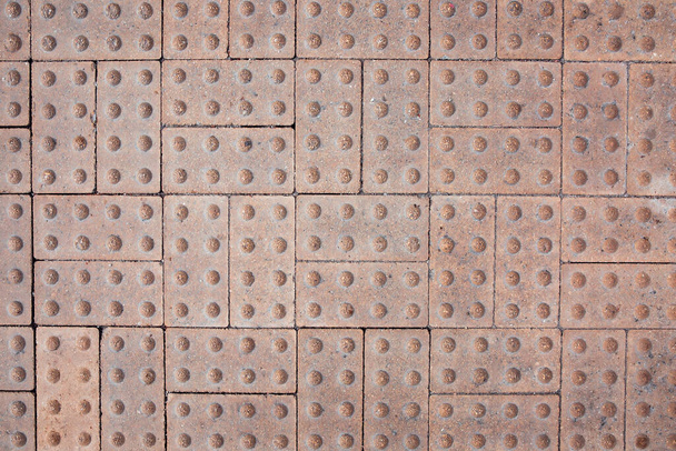 Tekstura płytek podłogowych dla osób niedowidzących i niewidomych. Pokrycie ulicy powierzchnią dotykową Braille 'a. - Zdjęcie, obraz