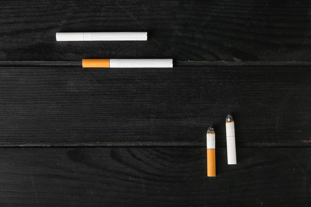 Различные сигареты на темном деревянном фоне - Фото, изображение