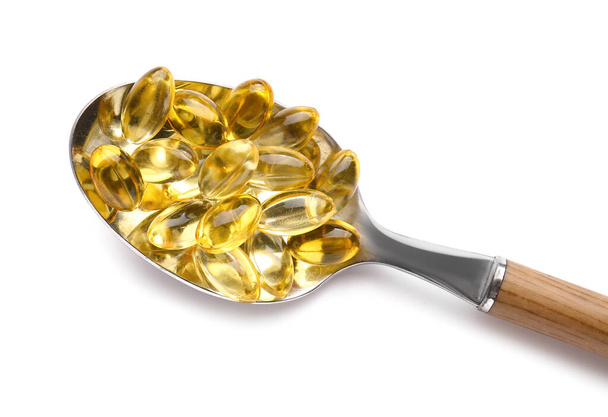 Spoon with fish oil capsules on white background - Photo, Image