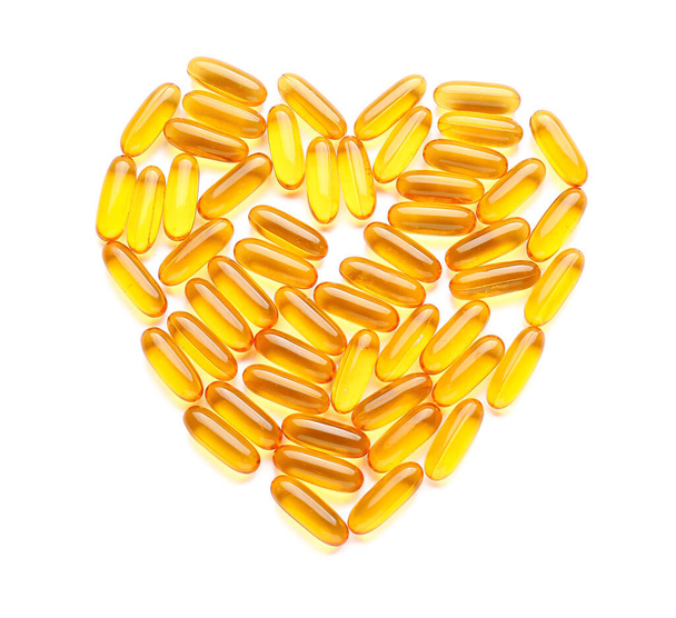 Heart shape made of fish oil capsules on white background - Foto, afbeelding