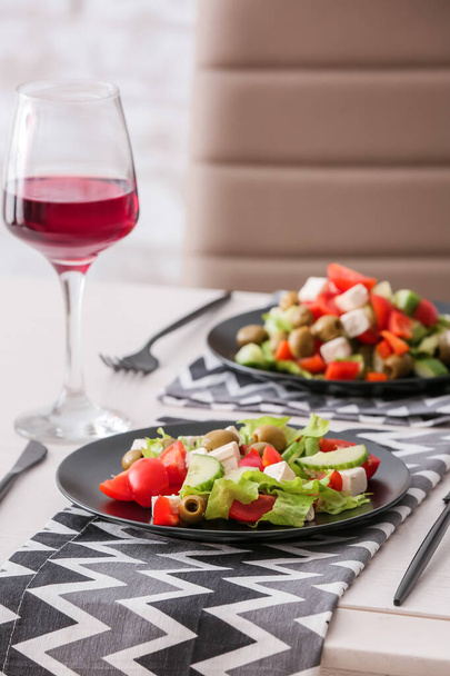 Plates with fresh Greek salad on table in restaurant - Fotoğraf, Görsel