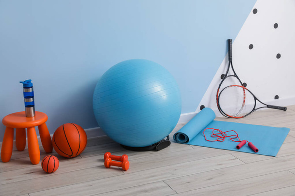 Set of sports equipment with fitness ball near color wall - Foto, Imagem