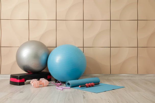 Set de equipamiento deportivo con pelotas de fitness cerca de la pared de color - Foto, Imagen