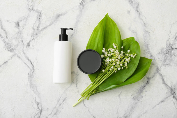 Cosmetic products and lily-of-the-valley flowers on light background - Valokuva, kuva