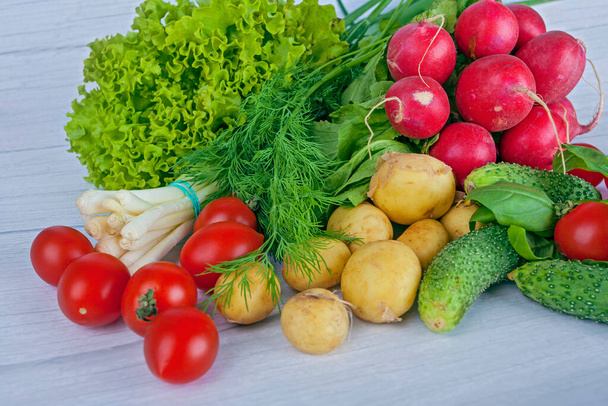 Fresh vegetables : adish, tomatoes ets, on light wooden background - Photo, Image