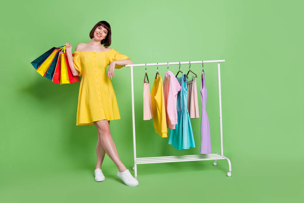Full length body size view of attractive cheerful girl bringing new things closet hobby isolated over green color background - 写真・画像