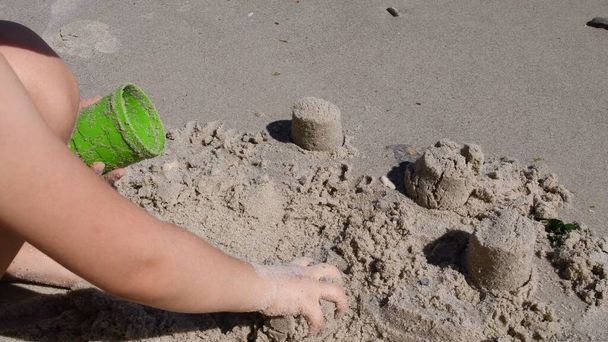 Kind bastelt Sandburg mit Sandschimmelwerkzeug am Strand - Foto, Bild