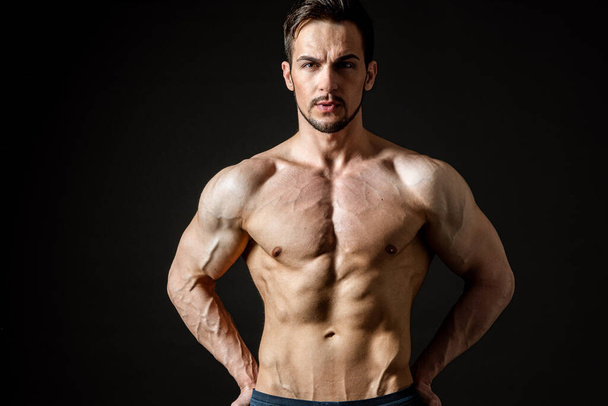 Portrait of an attractive muscular man on a dark background - Fotografie, Obrázek