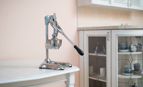 сталевий соковижималка прес на полиці вдома на кухні
 - Фото, зображення