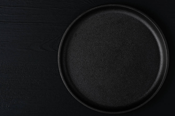 Empty metal tray on a black background. Space for text - Фото, изображение