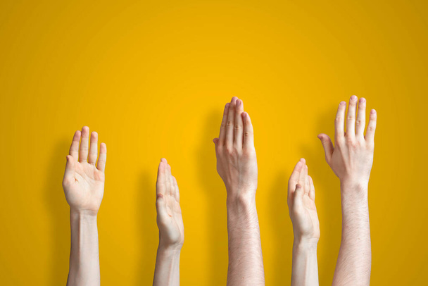 die fünf erhobenen menschlichen Hände isoliert auf dem farbenfrohen Hintergrund als Konzept der Abstimmung und stimmen überein - Foto, Bild