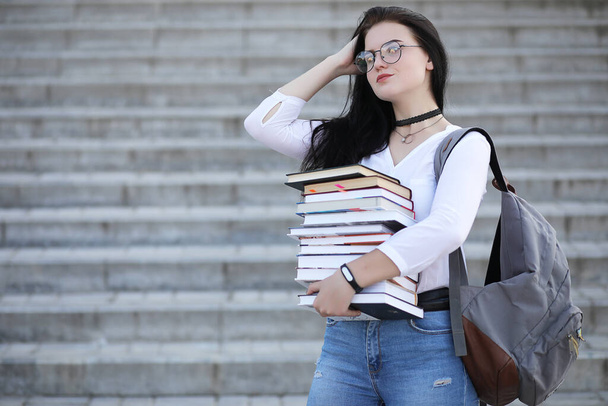 Giovane studentessa per strada con uno zaino e un libro - Foto, immagini