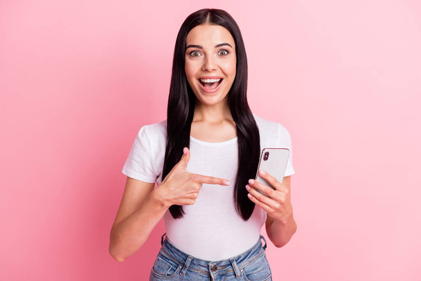 Portrait of attractive cheerful girl using demonstrating gadget like follow isolated over pink pastel color background - Fotografie, Obrázek