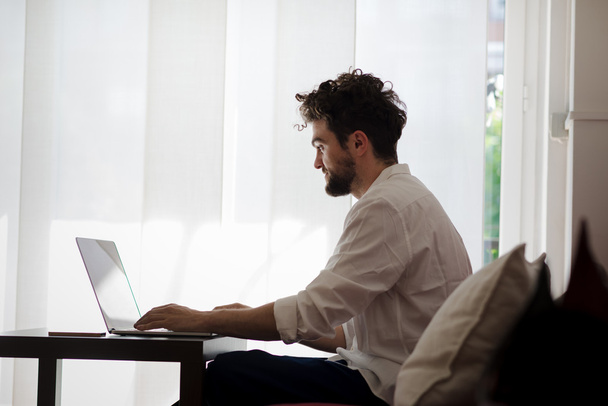 guapo hipster moderno hombre trabajando en casa usando el ordenador portátil
 - Foto, imagen