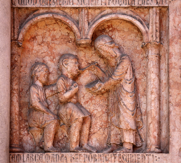 Christus uitvoeren van werken van barmhartigheid opluchting naar aanleiding van de doopkapel, parma, Italië - Foto, afbeelding