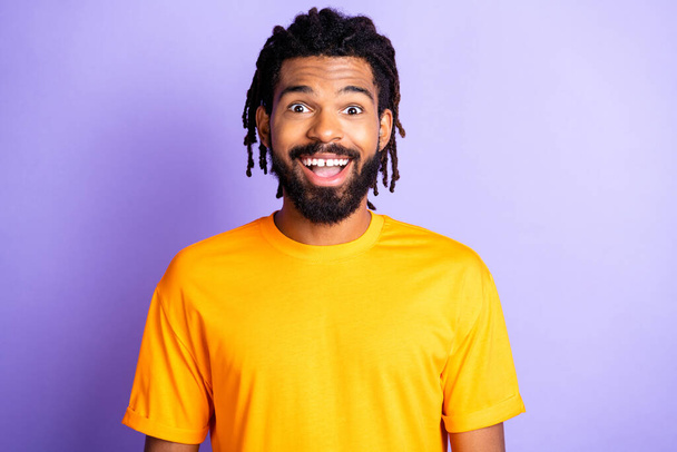 Portrait of nice impressed brunet guy wear orange t-shirt isolated on vibrant lilac color background - Foto, immagini