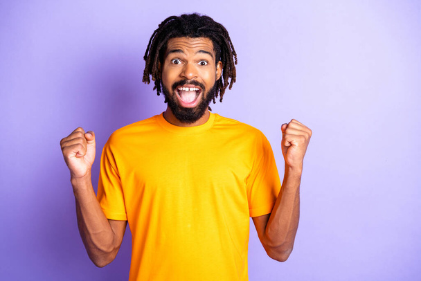 Portrait of nice hooray brunette hairdo guy yell wear orange t-shirt isolated on lilac color background - 写真・画像