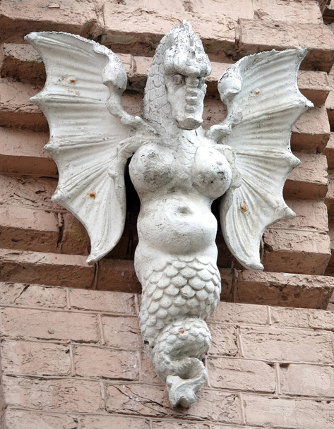 Kijev, Ukrajna június 10, 2021: A Griffin szobra - Sárkány női mellgel, szárnyakkal és férfi arccal egy épület homlokzatán Kijev központjában - Fotó, kép