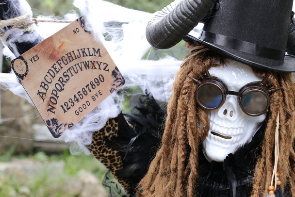 close-up portrait of person in scary Halloween mask holding Ouija spiritual board - Photo, image