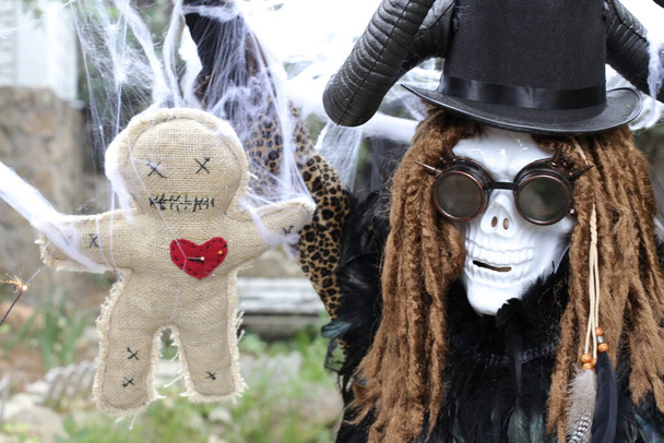 close-up portret van persoon in eng Halloween masker met voodoo pop - Foto, afbeelding