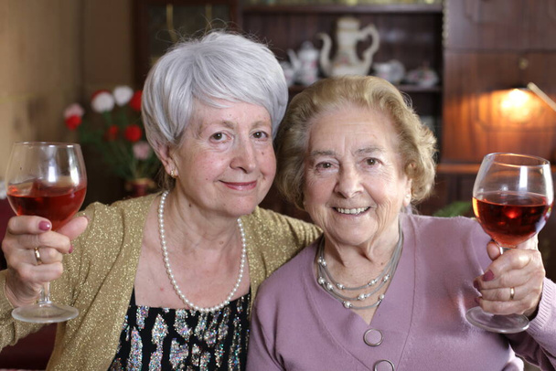 πορτρέτο δύο ώριμες γυναίκες με κόκκινο κρασί περνούν χρόνο μαζί στο σπίτι - Φωτογραφία, εικόνα