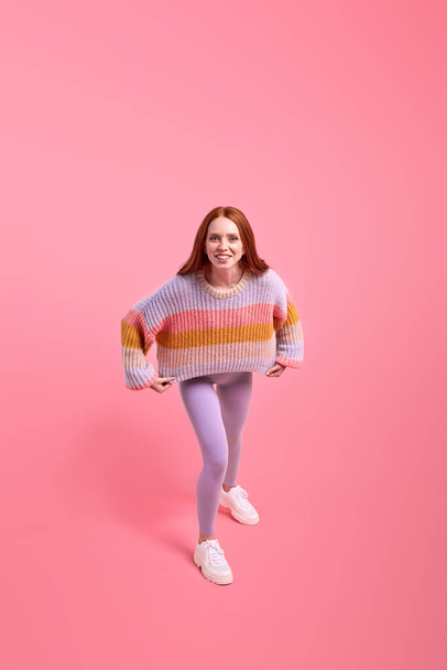 Excited funny redhead woman in casual wear have fun alone in studio, posing at camera - Fotoğraf, Görsel