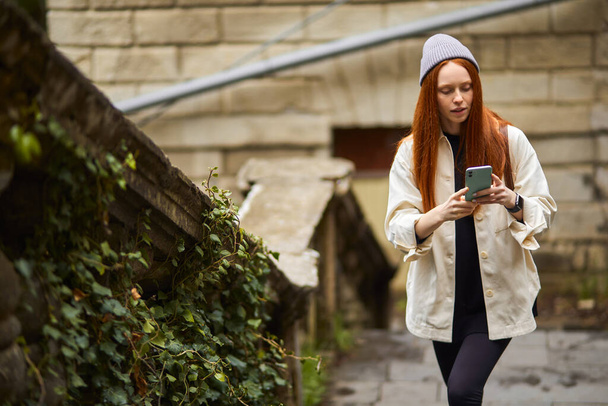 Focused Caucasian Female Use Smartphone While Walking, In Search Of Beautiful Place - Foto, immagini