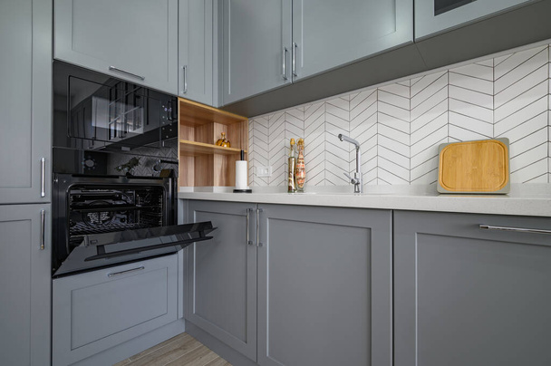 Closeup to corner of grey and white modern kitchen furniture - Photo, Image