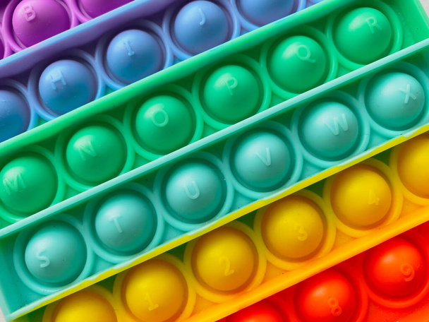 Nahaufnahme Textur Regenbogen Antistress Finger Push-Spielzeug für Kinder Pop it - Foto, Bild