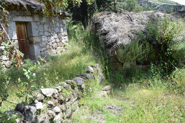 Casa de campo rustica con techo de paja y piedras - Фото, зображення