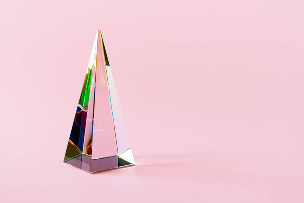 Glass pyramid prism on pink background with colorful sunlight reflection with copy space - Foto, afbeelding