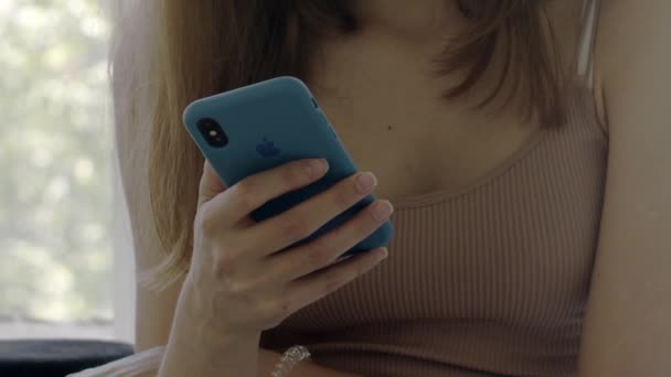 15 August 2018. Close-up. The girl holds an iPhone in a blue case in her hands and presses on it. Editorial documentary. - Footage, Video
