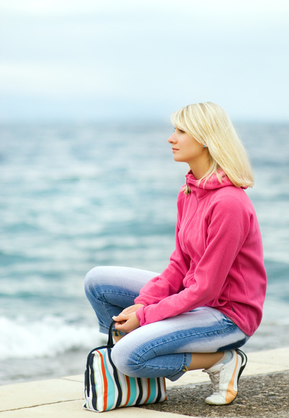 smutna kobieta siedzi w pobliżu oceanu - Zdjęcie, obraz