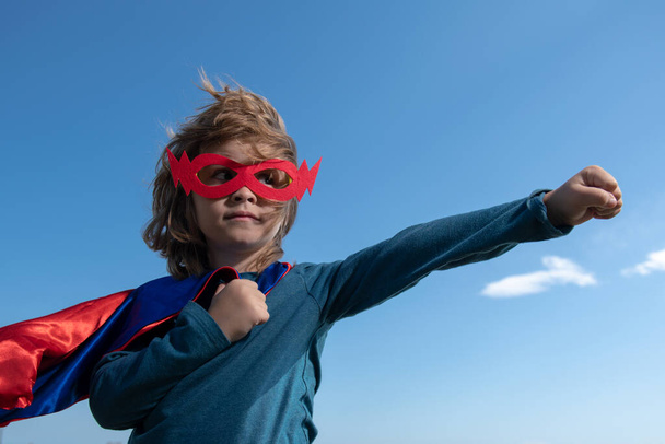 Kid having fun outdoors in super man cloak. Boy playing superhero. Success and winner concept. - Photo, image