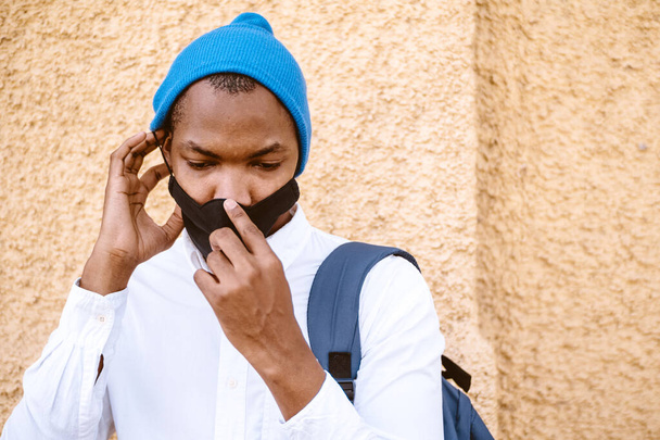 A portrait of an afro American male trying to remove his mask - Foto, afbeelding