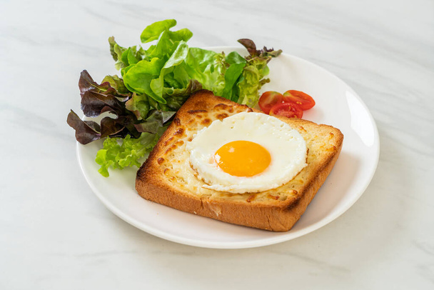 homemade bread toasted with cheese and fried egg on top with vegetable salad for breakfast - Фото, зображення