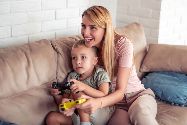 Familia feliz jugando videojuegos en casa y divirtiéndose juntos. - Foto, imagen