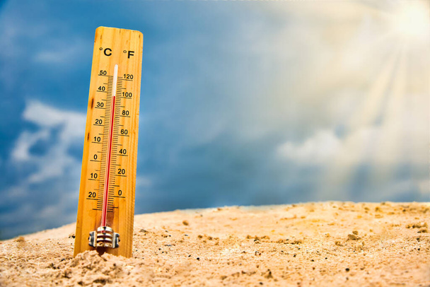 Teploměr počasí v písku proti obloze ukazuje vysokou okolní teplotu - Fotografie, Obrázek
