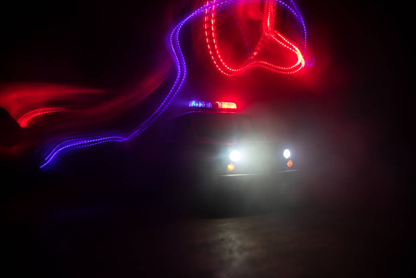 Poliisiauto jahtaa yöllä autoa, jolla on sumutausta. Hätäkeskus. Poliisiauto ajaa ylinopeutta rikospaikalle. Luova sisustus. Valikoiva painopiste - Valokuva, kuva