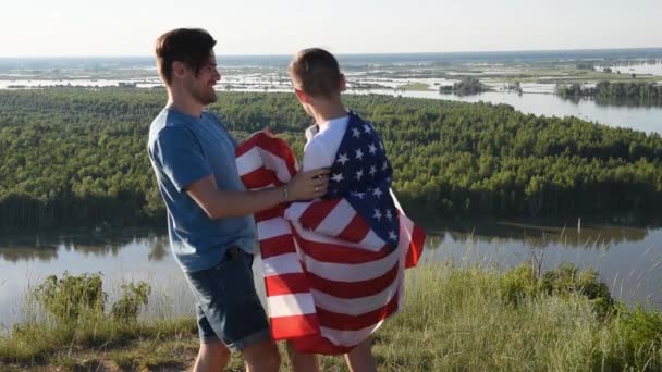 Sevimli genç bir çocuk ve babası Amerikan bayrağını havada tutuyorlar. - Video, Çekim