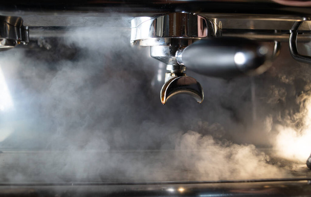 Jó sok gőz a kávéfőzőből. A kávéfőző füstöl és gőzöl. felületek gőzkezelése kávézóban. - Fotó, kép