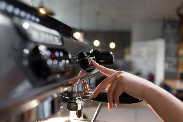 Barista przygotowuje profesjonalny ekspres do kawy do pracy w restauracji lub kawiarni. Proces przygotowania ekspresu do kawy do przygotowywania kawy espresso. - Zdjęcie, obraz