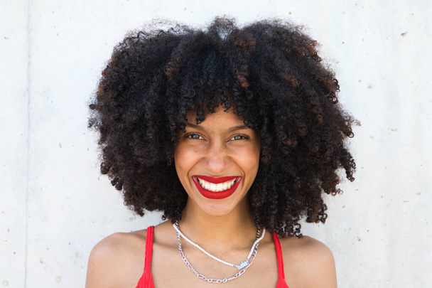 美しいアフリカ系アメリカ人の女性が笑顔でカメラを見て顔で異なるポーズやジェスチャーをしています。女性は赤いトップと赤い口紅をつけている。コンセプト幸福 - 写真・画像