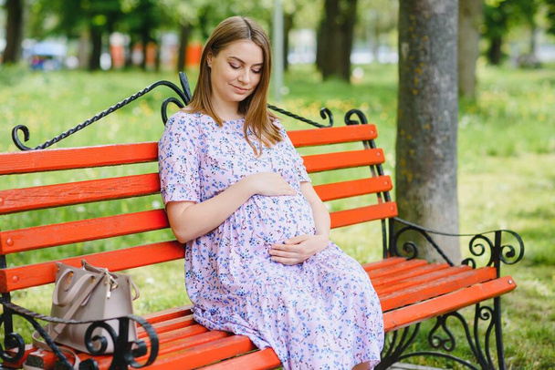 pregnant woman doing yoga in the park. sitting on the grass. - Zdjęcie, obraz