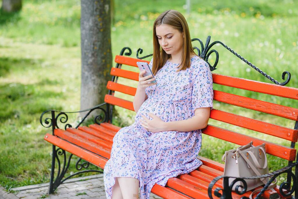 Pregnant woman resting in the park - Photo, image