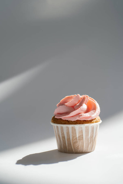 Cupcake on a white sunny background with a shadow. - Photo, Image