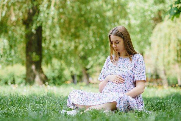 Pregnant woman resting in the park - Foto, afbeelding