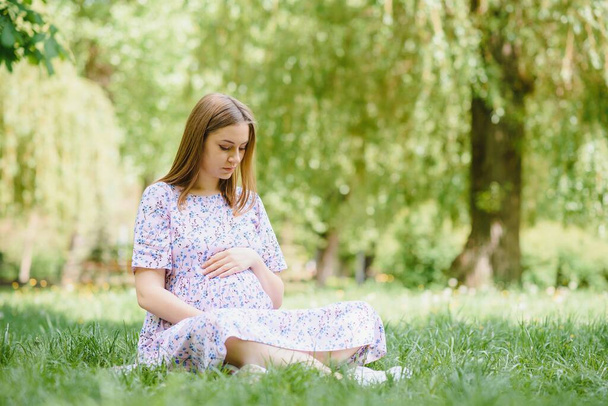 Beautiful pregnant woman relaxing in the park - Photo, Image