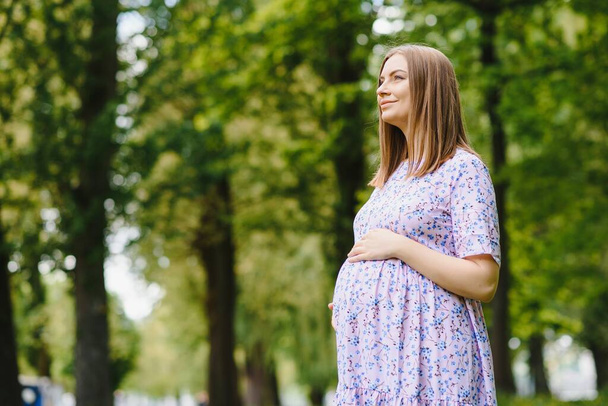 The pregnant girl on walk in city park - Foto, imagen